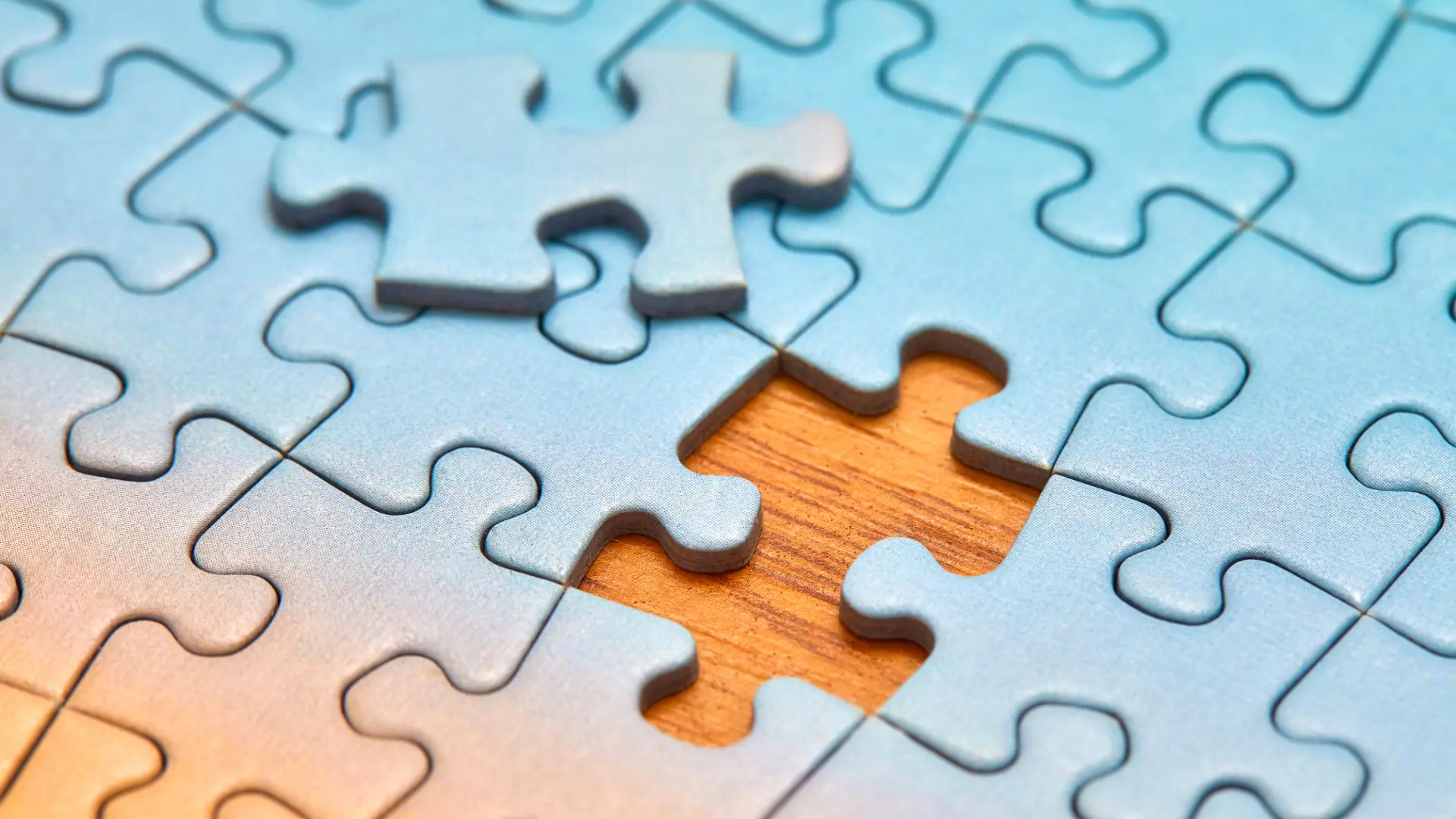 Close-up of a blue puzzle with a missing piece revealing wood underneath, symbolizing healing, reflection, and personal growth – Chronic Health Wisdom